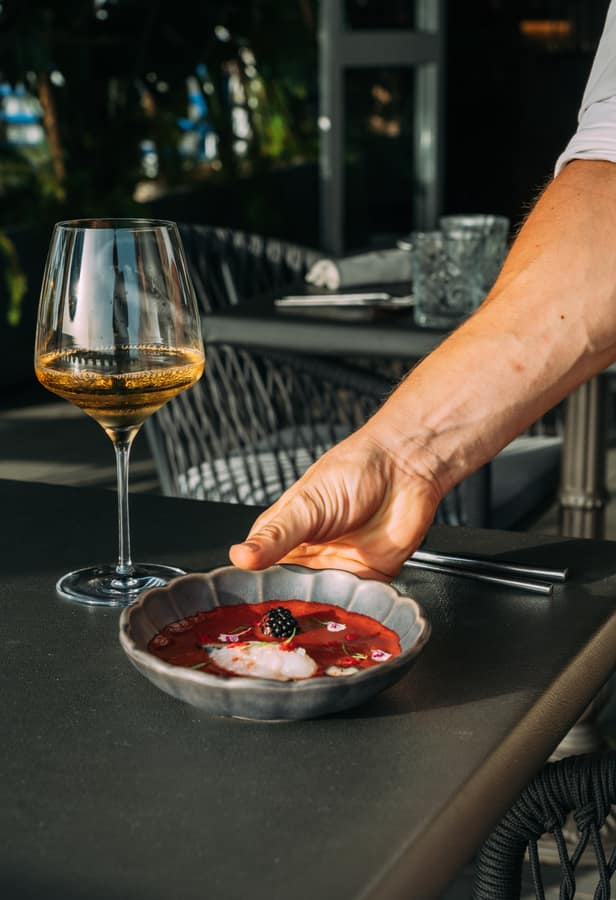 An appetiser served beside a glass of white wine