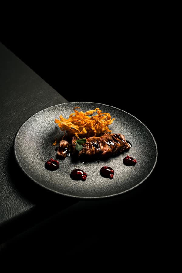 Grilled dish with a crisp topping on black ceramic