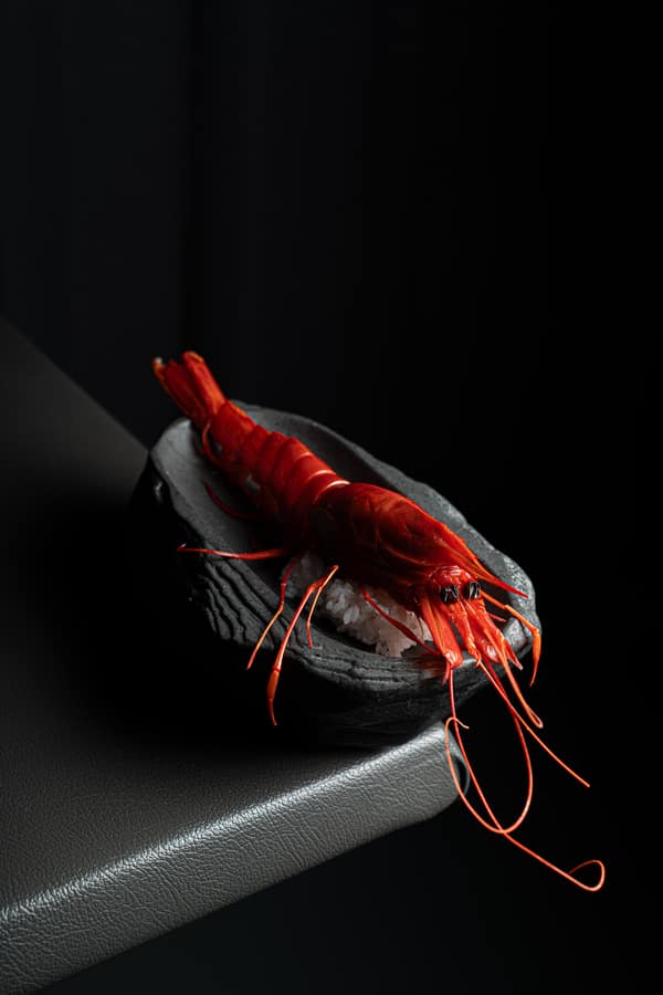Scarlet prawn presented on black stone