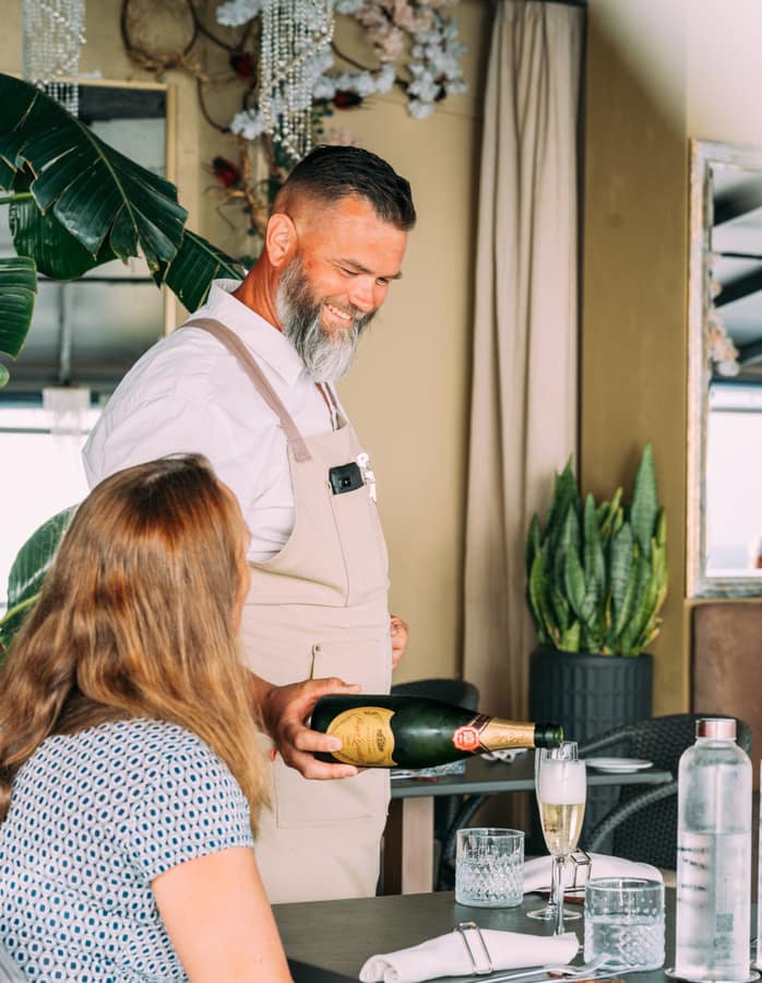 Sommelier pouring champagne at the table