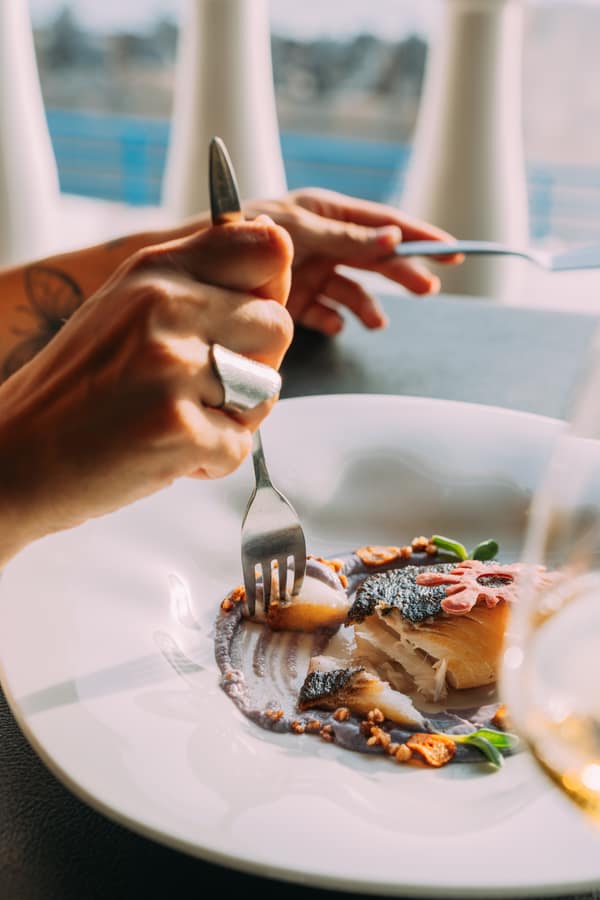 A guest enjoying a fish dish with sea views