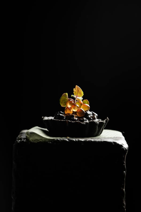 Dark dessert finished with edible flowers
