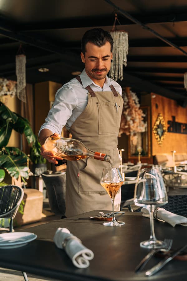 Waiter pouring wine in the dining room